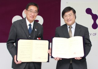 協定書を掲げる田辺市長と島田学長